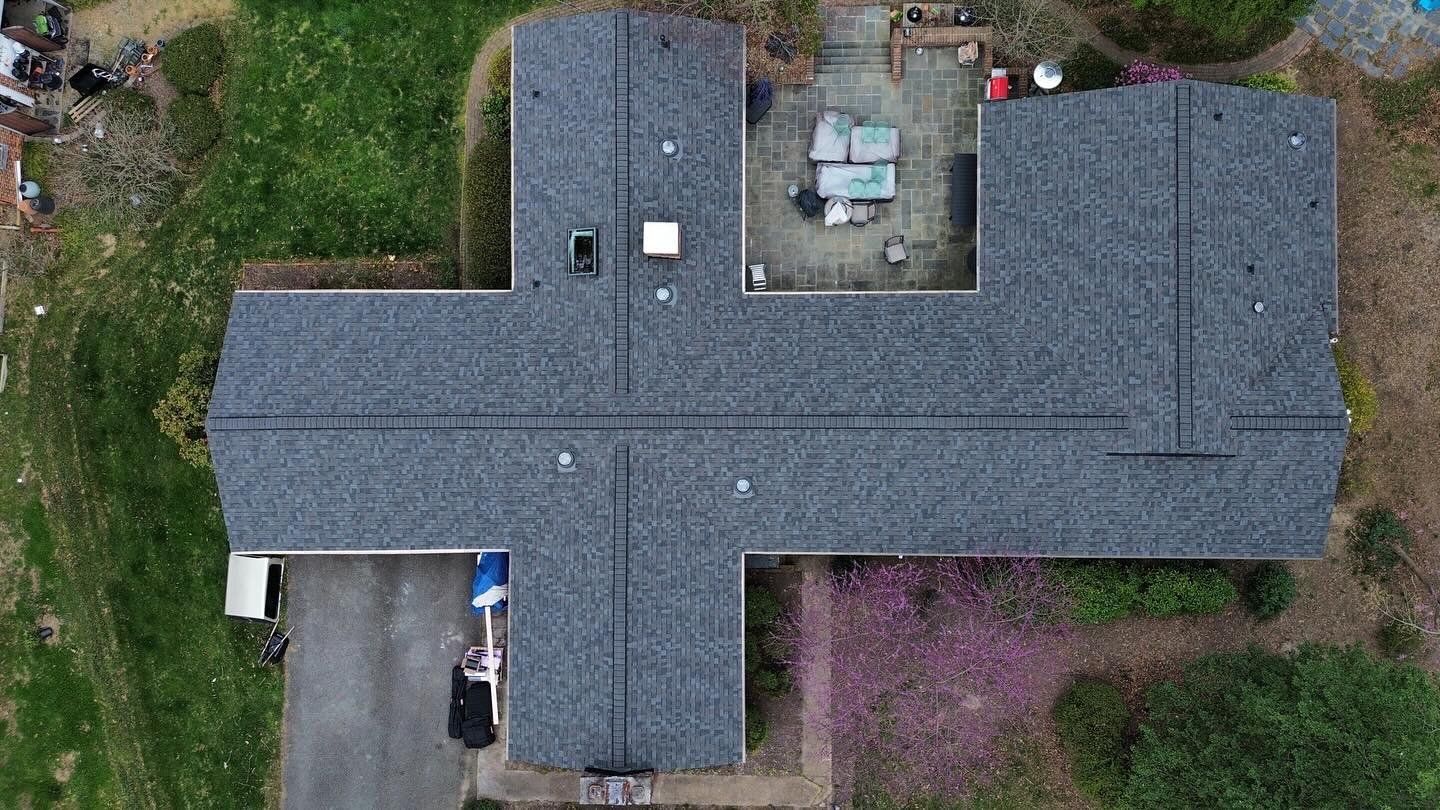 An aerial view of a house with a roof that looks like a cross.