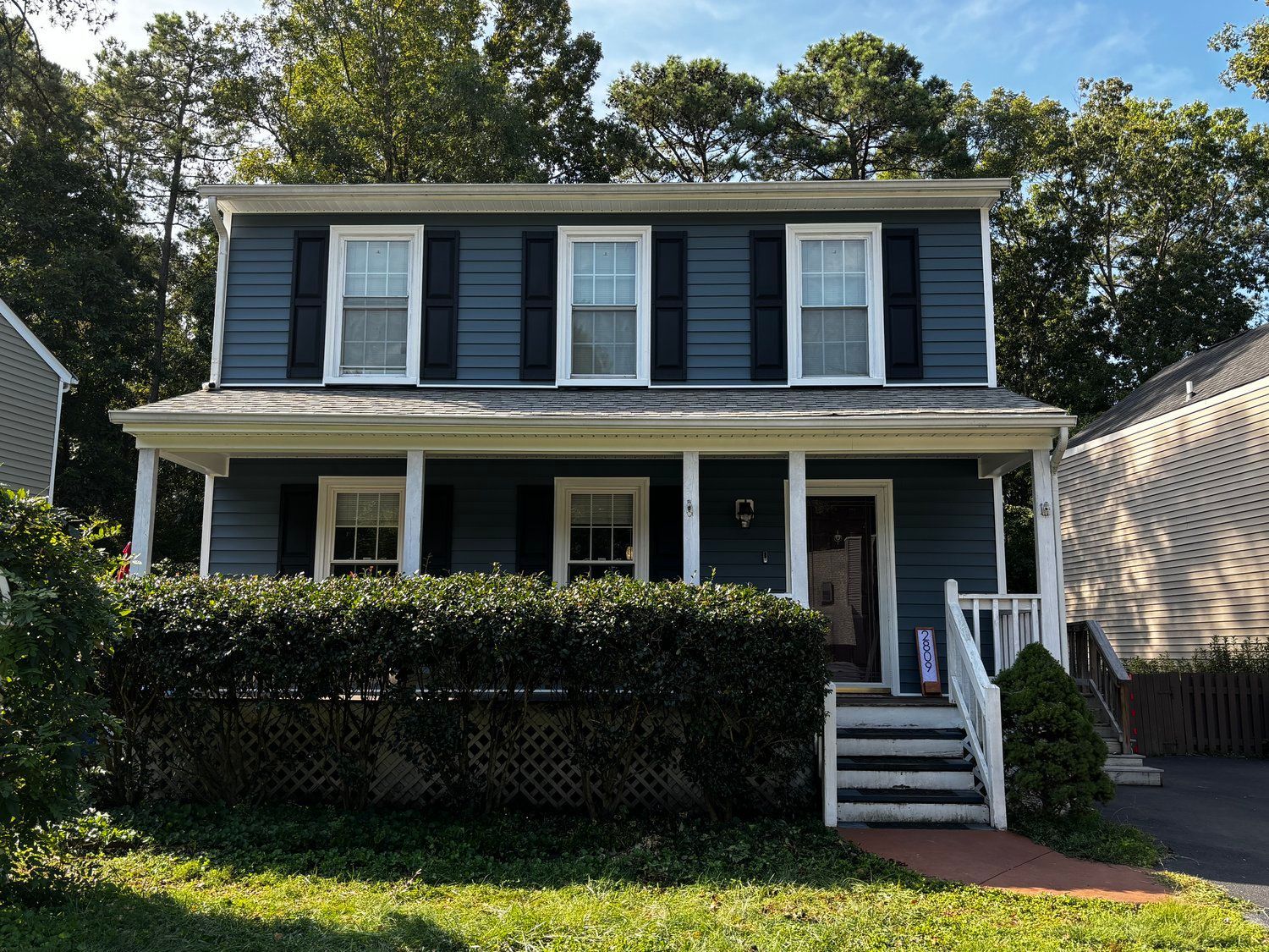 A blue house with white trim and black shutters