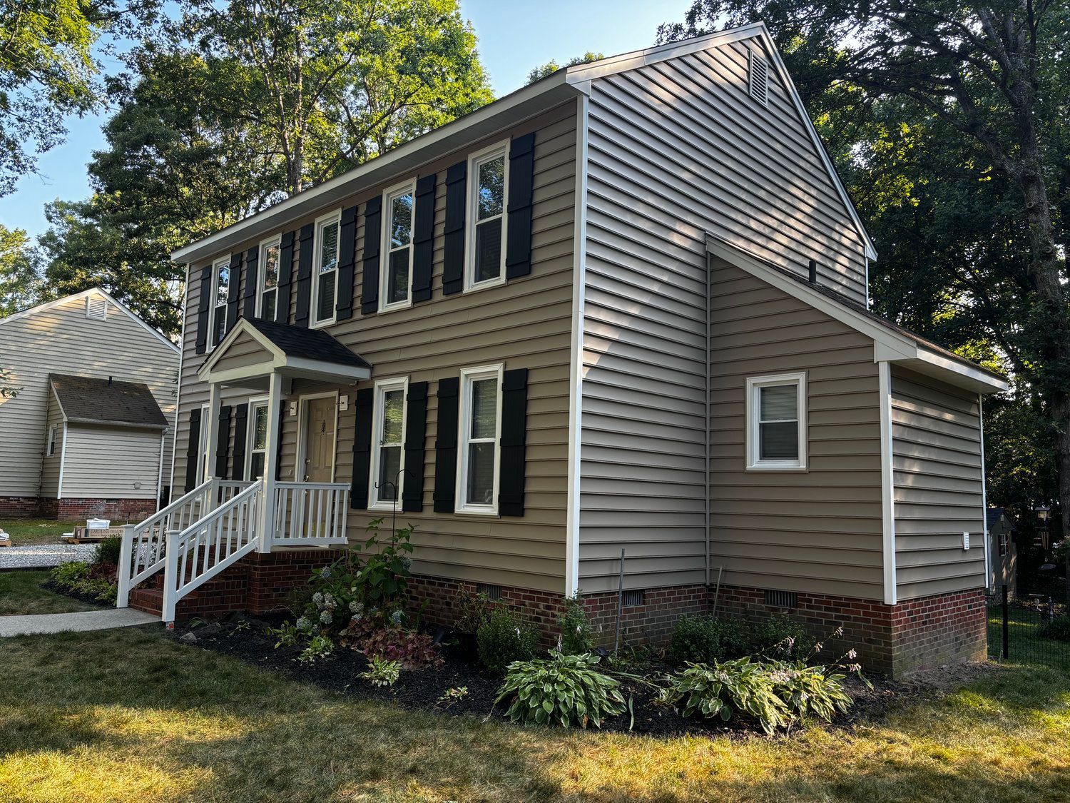 A large house with a lot of windows and black shutters.