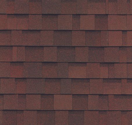 A close up of a row of red shingles on a roof.