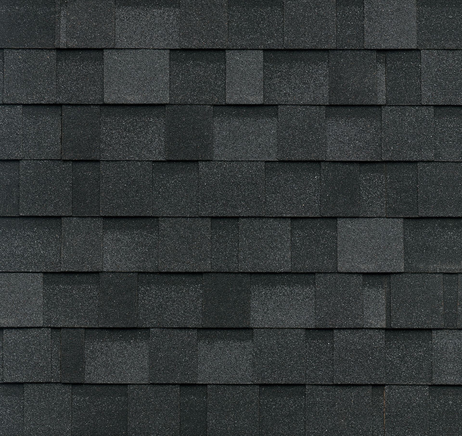 A close up of a row of black shingles on a roof.