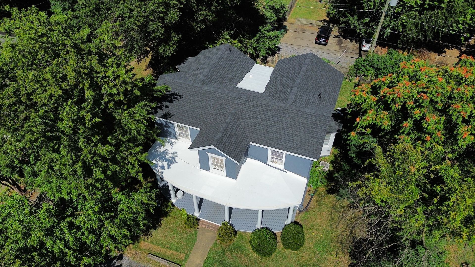 An aerial view of a large house surrounded by trees.