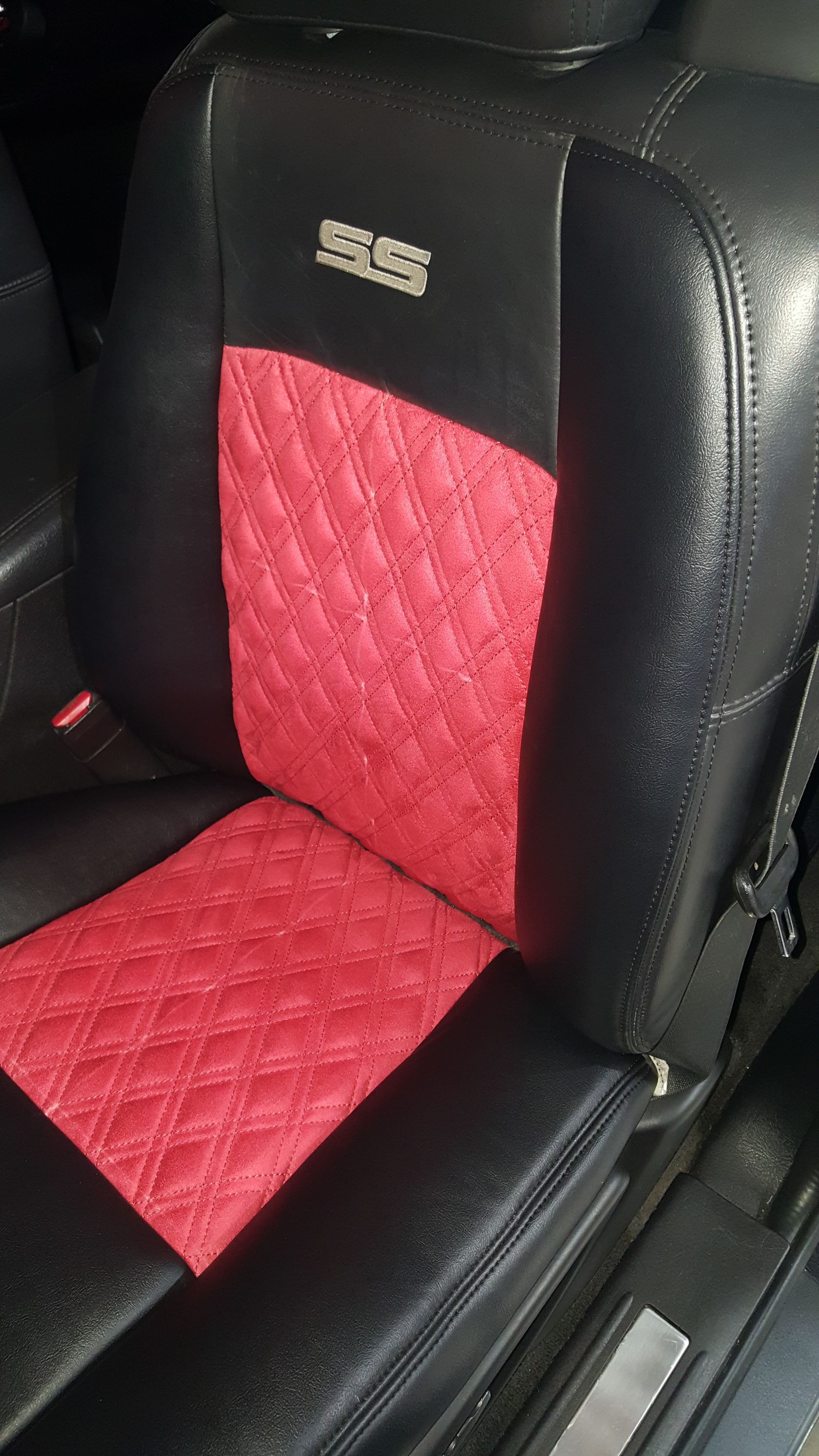 A close up of a red and black seat in a car.