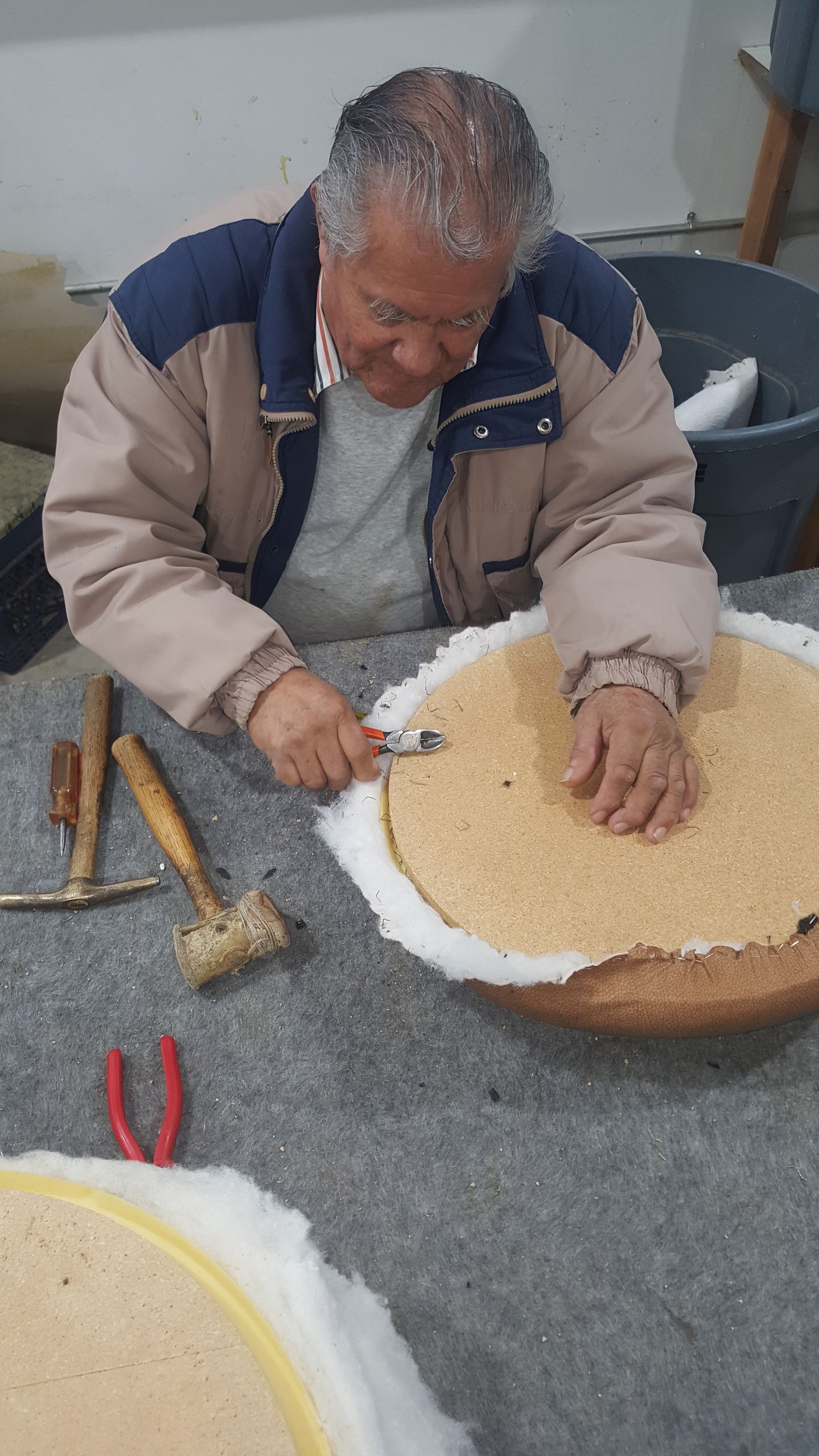 A man is sitting at a table working on a piece of bread.