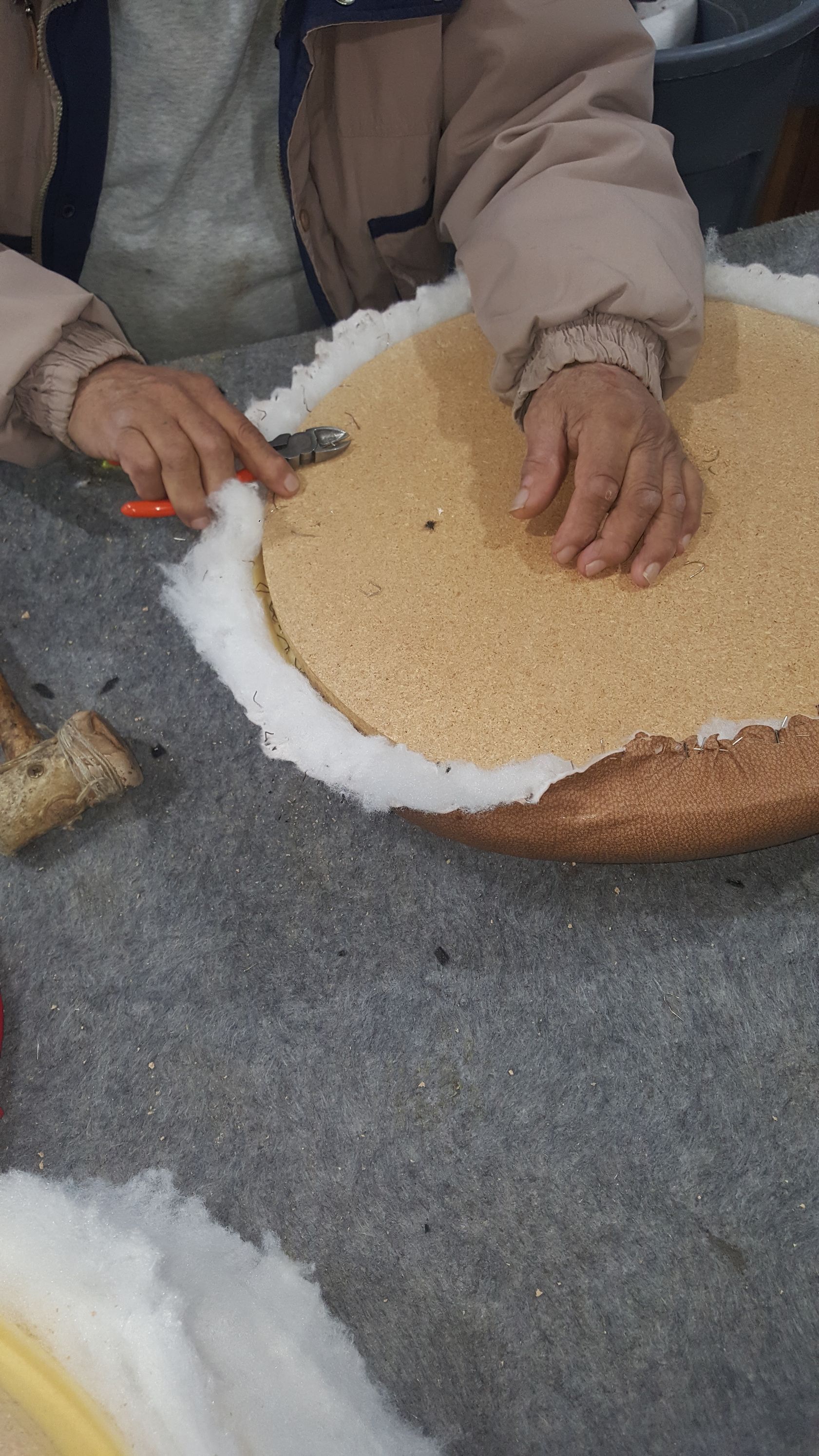 A person is cutting a piece of bread with scissors on a table.