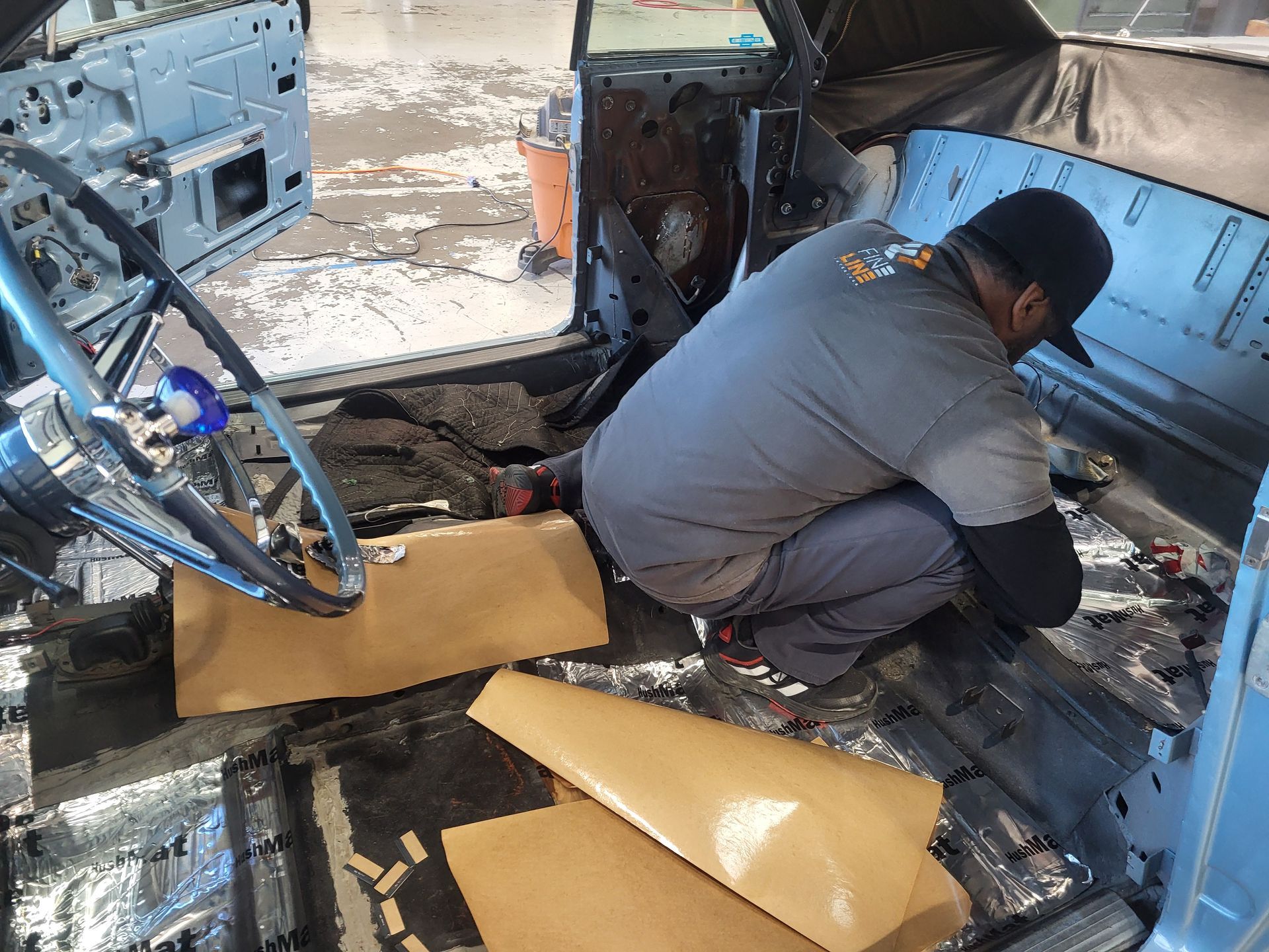 A man is working on the inside of a car.