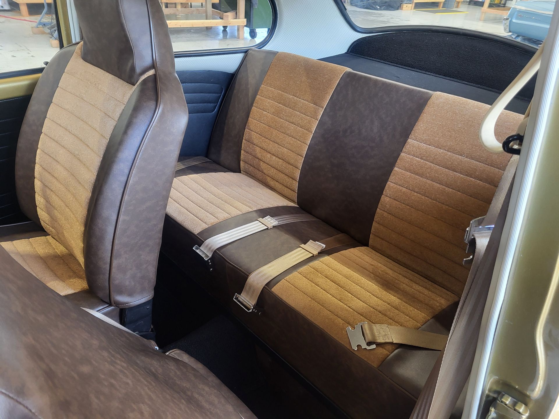 The back seat of a car with brown and tan seats