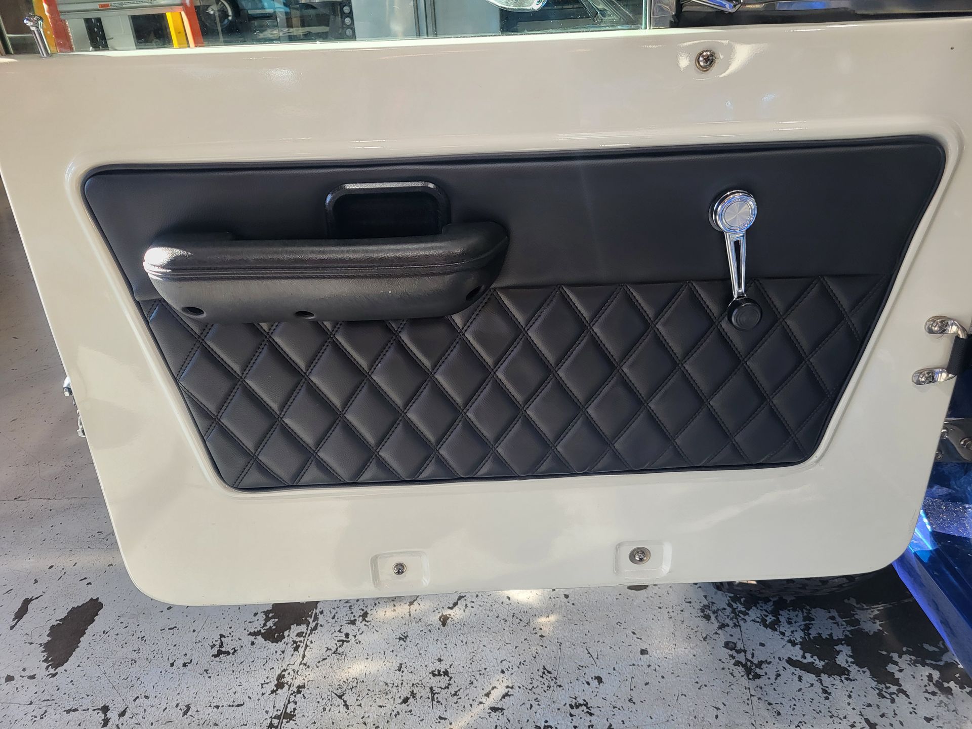 A white door with a black quilted door panel and a handle.