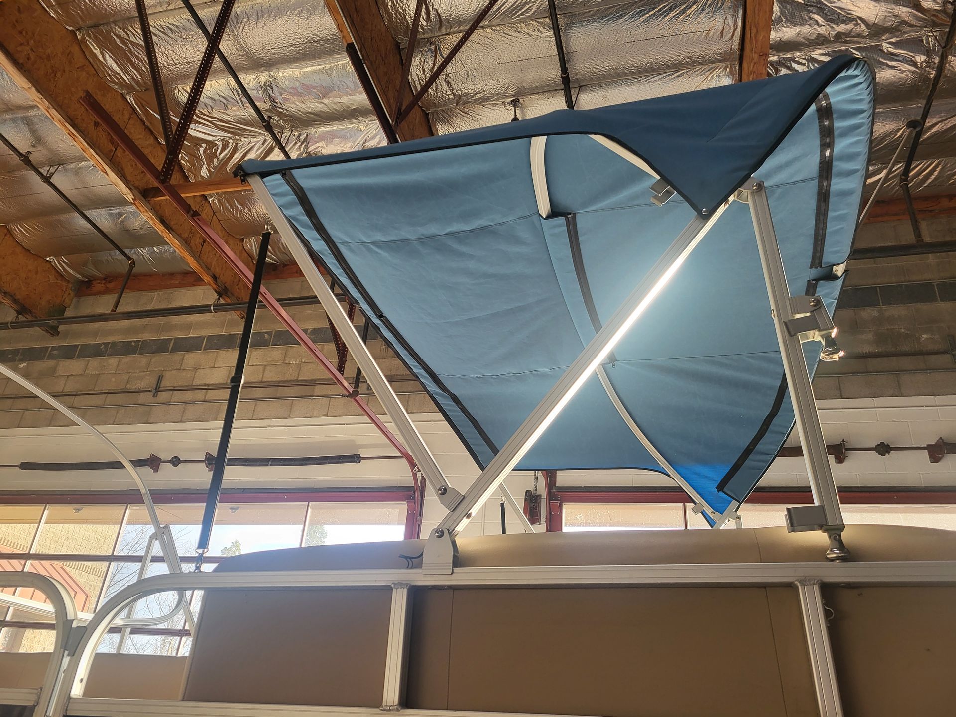 A blue canopy is hanging from the ceiling of a boat.