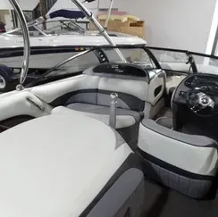 The inside of a boat with a steering wheel and seats.