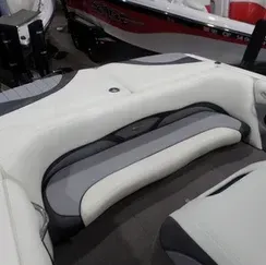 The back seat of a boat with a gray and white seat cushion.