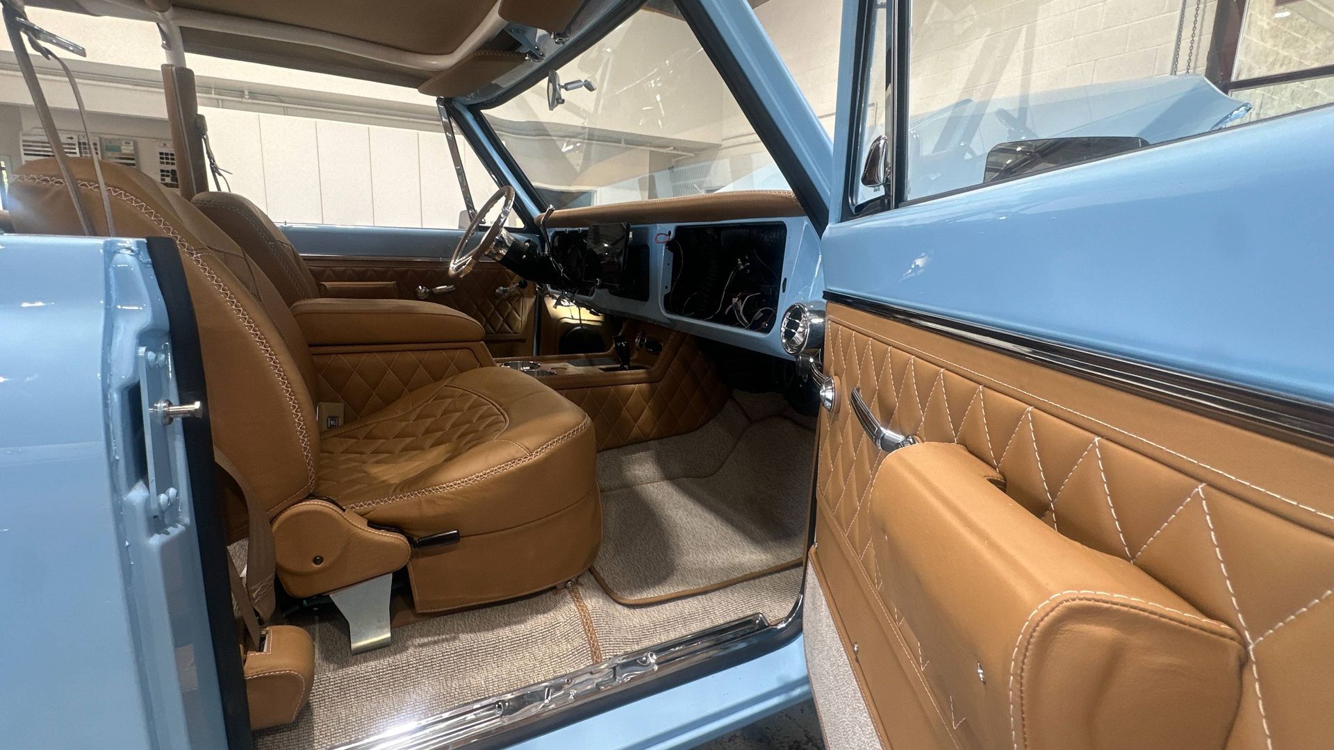 Tan car interior with a subwoofer built in, quilted details.