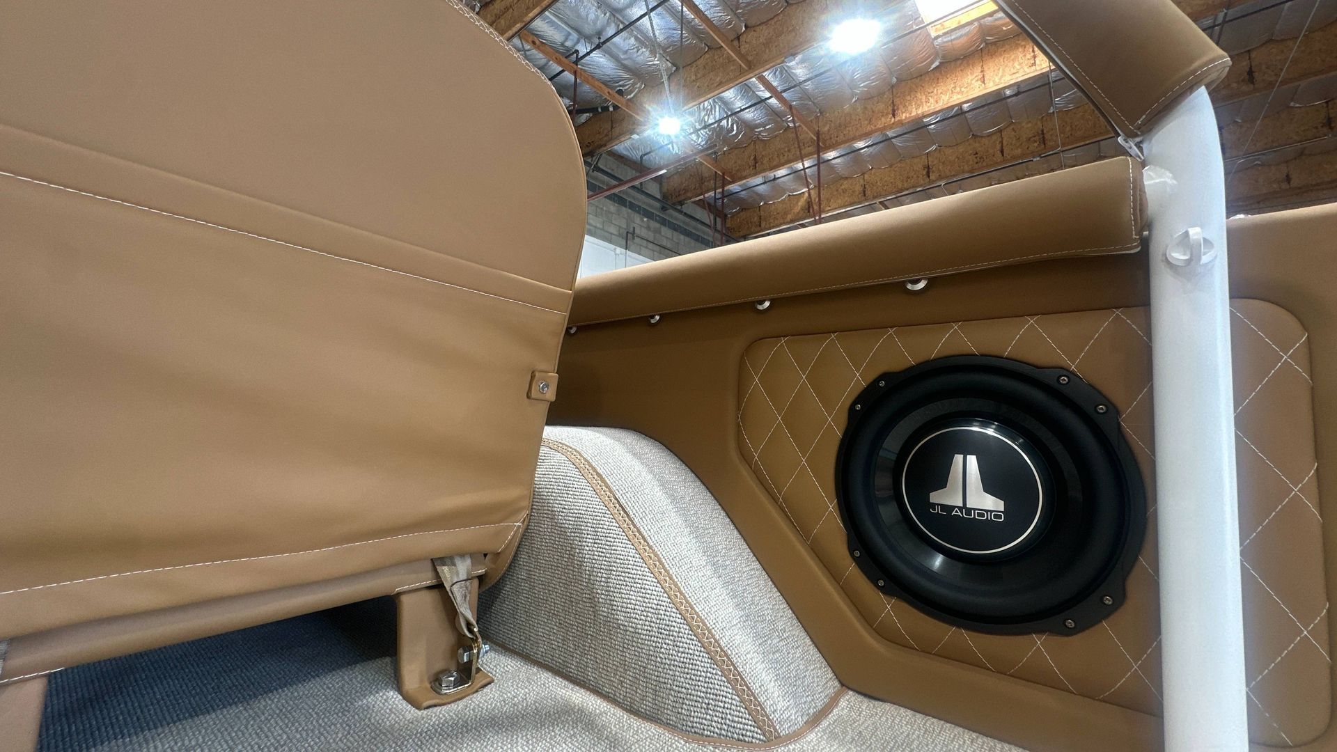 Tan car interior with a subwoofer built in, quilted details.