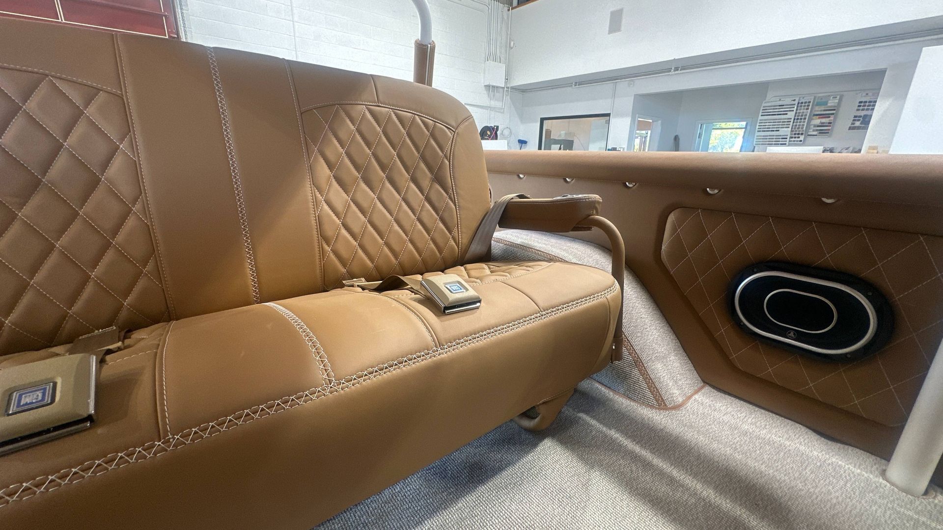 Tan car interior with a subwoofer built in, quilted details.