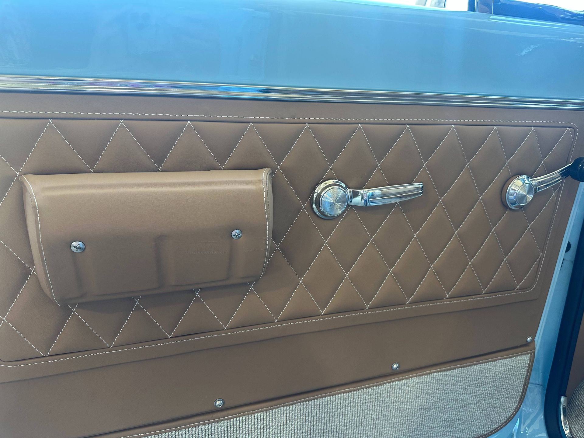 Tan car interior with a subwoofer built in, quilted details.