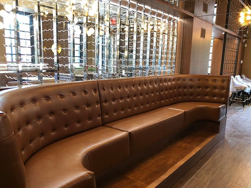 Living room with red sofa, small round tables, and a bench.