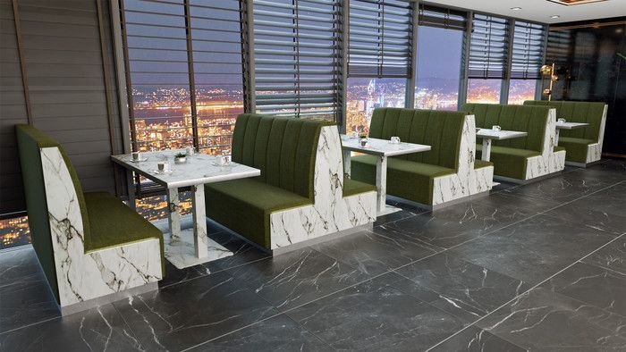 Green booths with marble accents and tables overlooking a cityscape through blinds.
