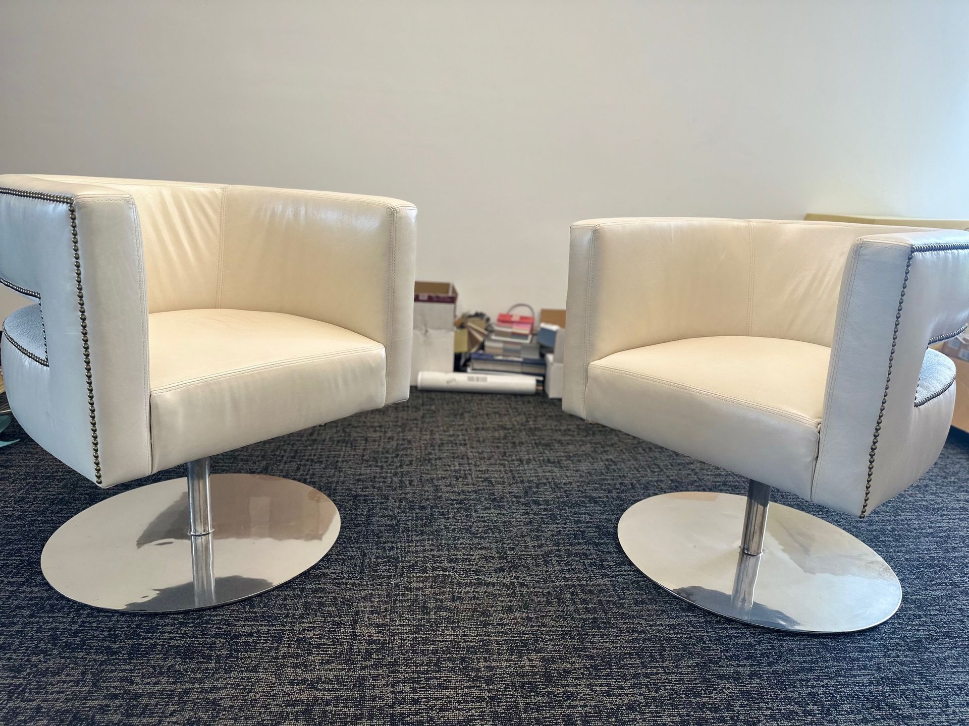Two white chairs are sitting next to each other in a room