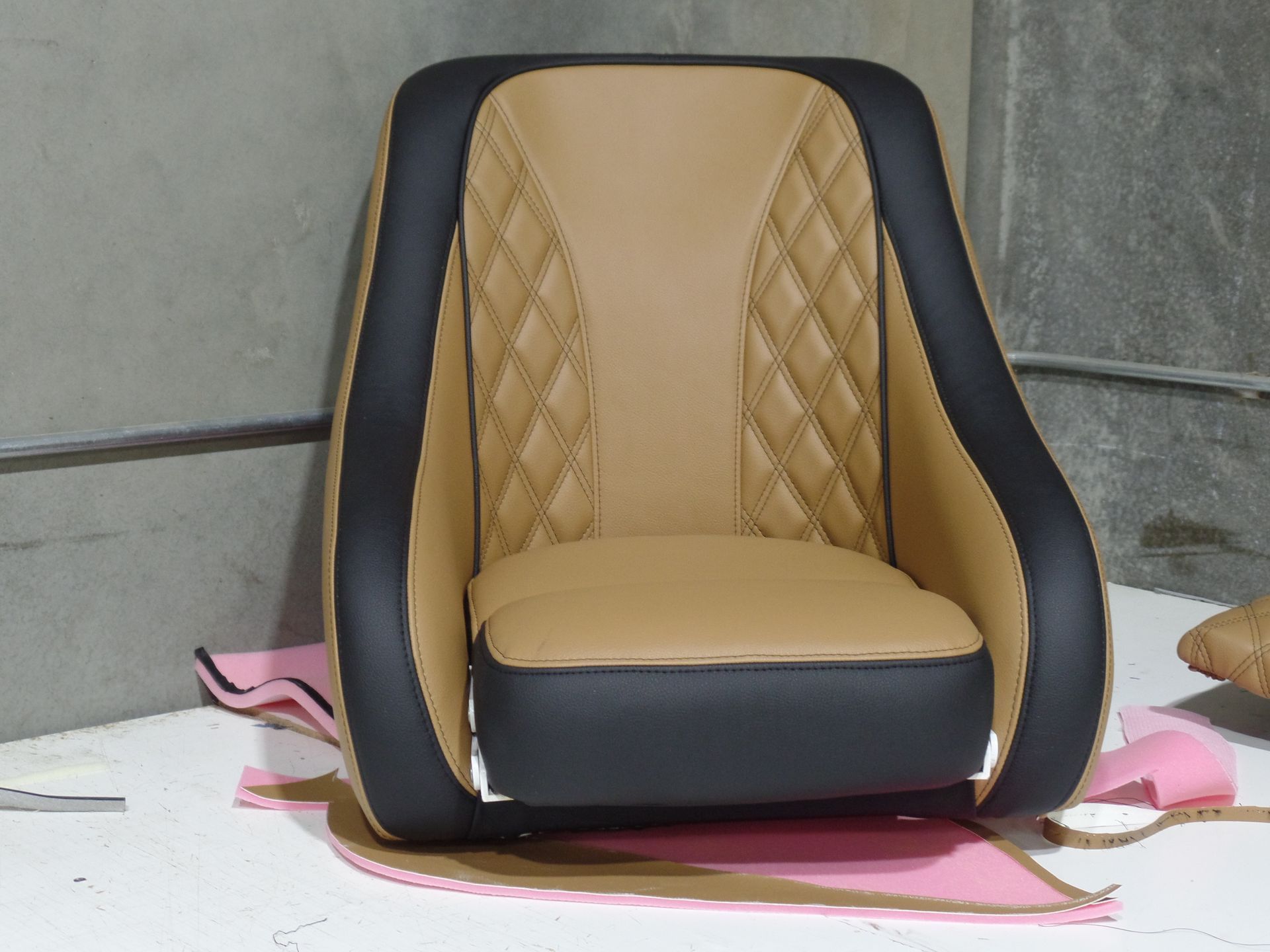 A tan and black chair is sitting on a white surface