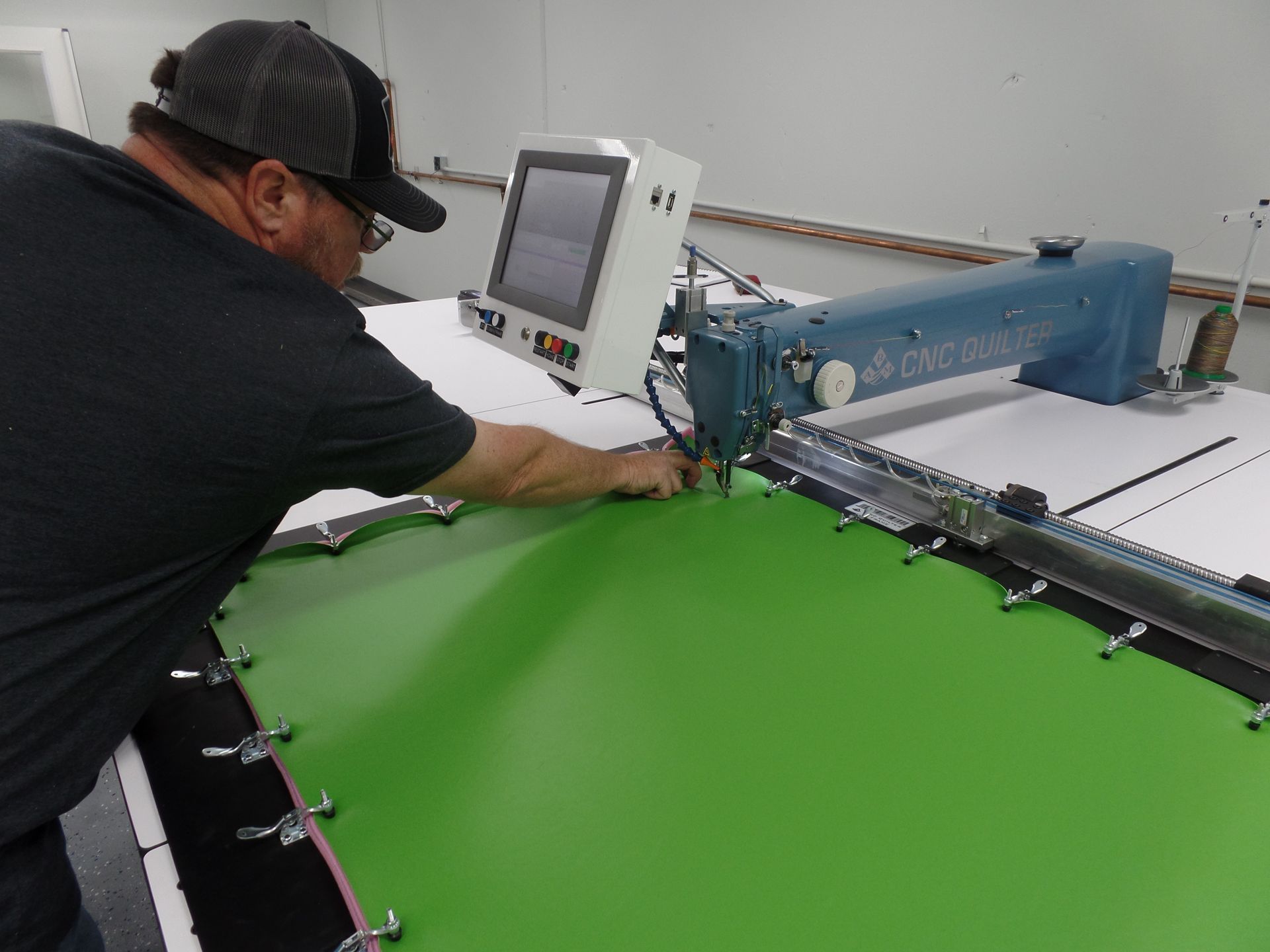 A man is working on a machine that is green