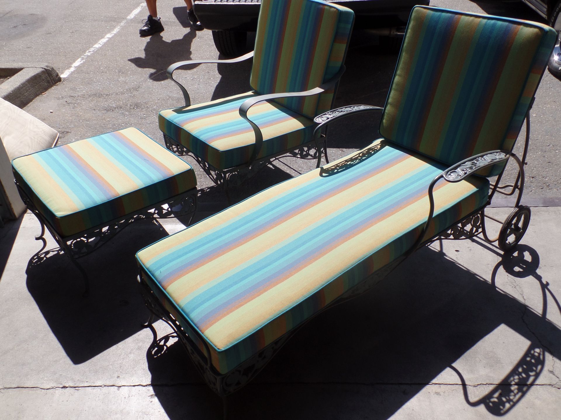 A set of lounge chairs and ottomans with striped cushions