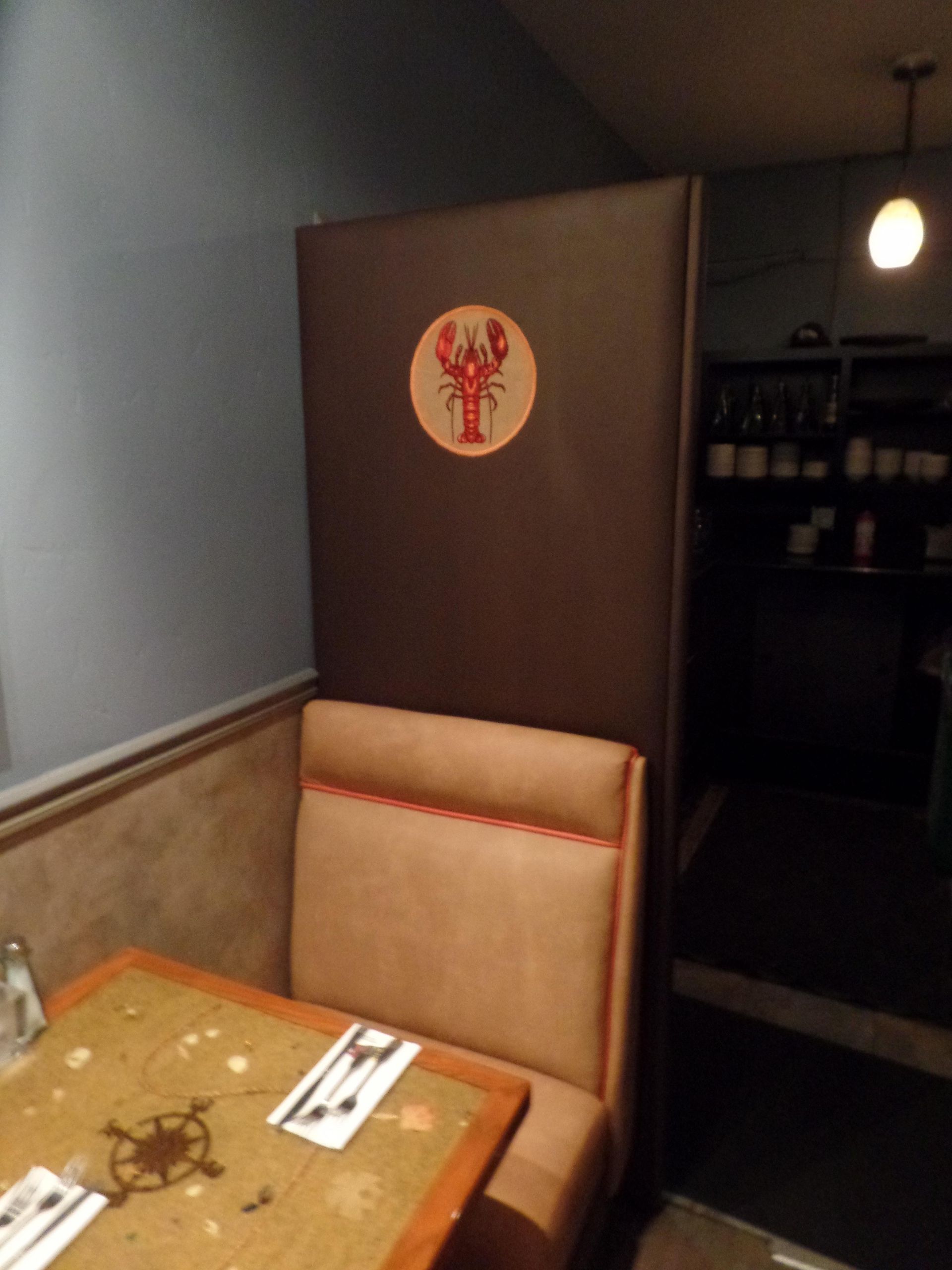 A restaurant booth with a lobster sticker on the wall