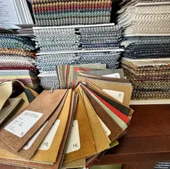 A bunch of fabric samples are stacked on top of each other on a table.