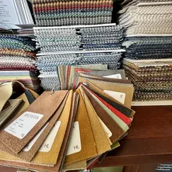 A bunch of fabric samples are stacked on top of each other on a table.