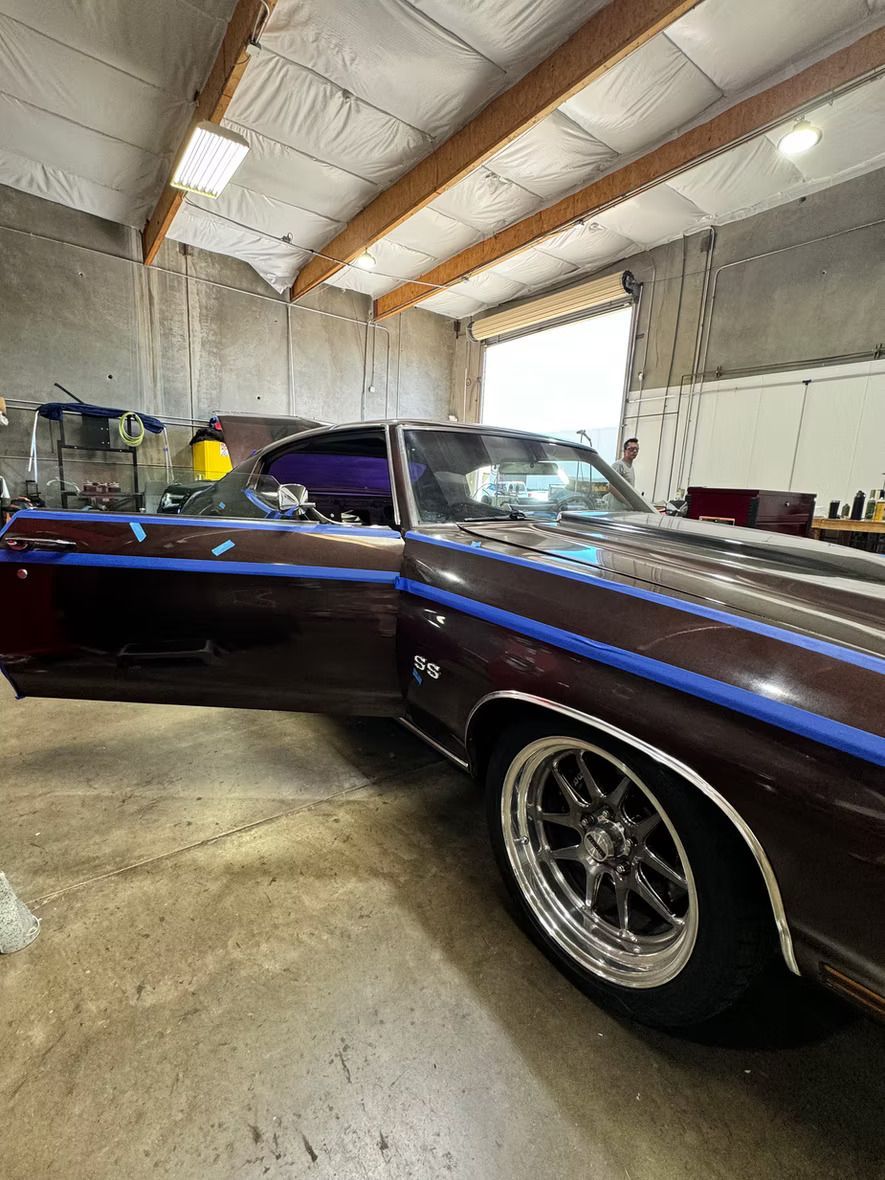 A car is sitting in a garage with the door open.