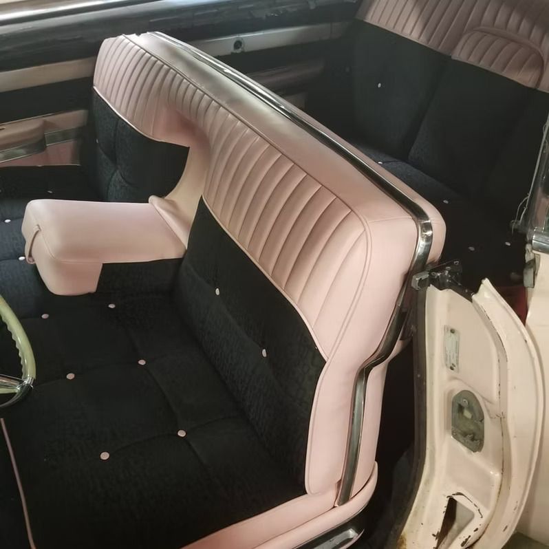The back seat of a car with pink and black seats