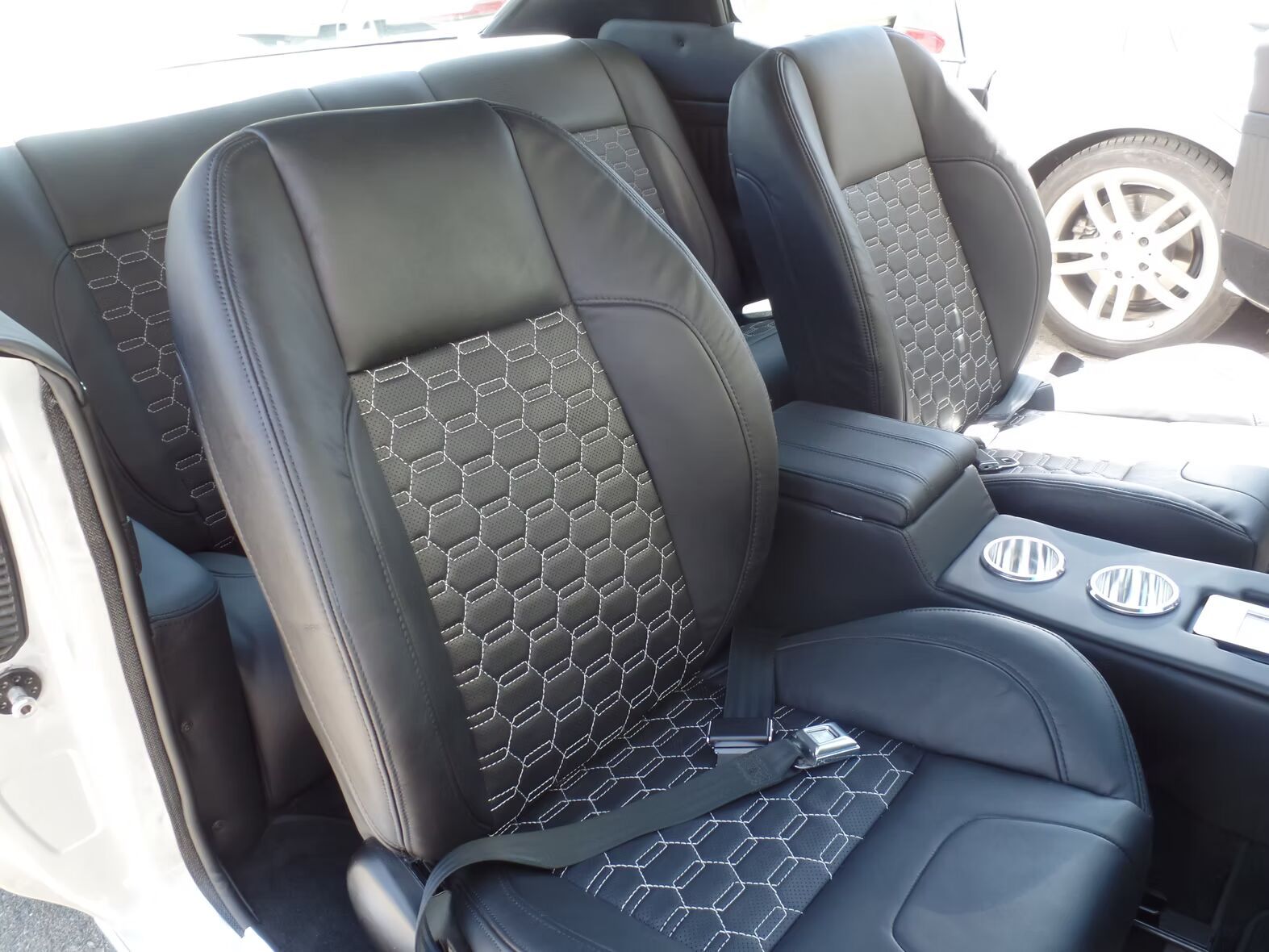 The back seat of a white car with black seats