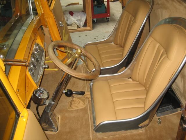 A yellow car with tan seats and a steering wheel