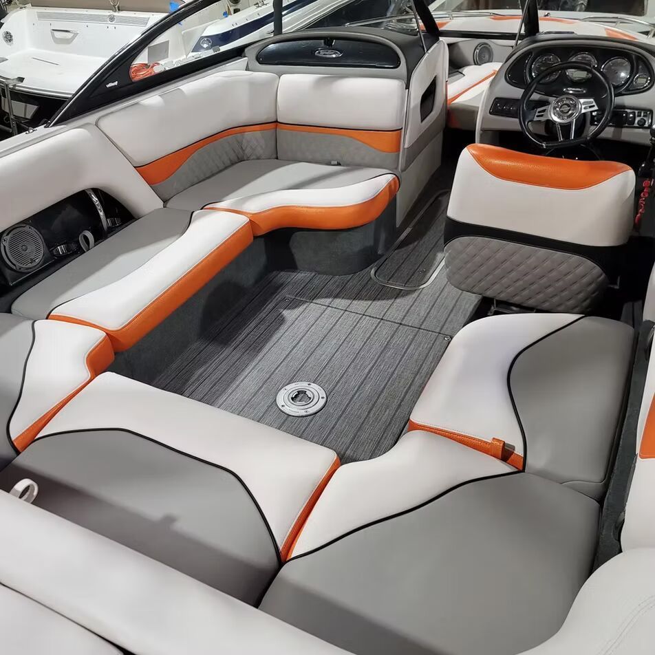 The inside of a boat with grey and orange seats
