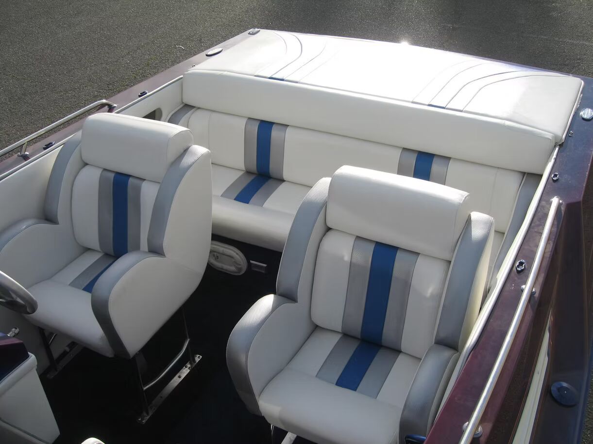 The inside of a boat with white and blue seats