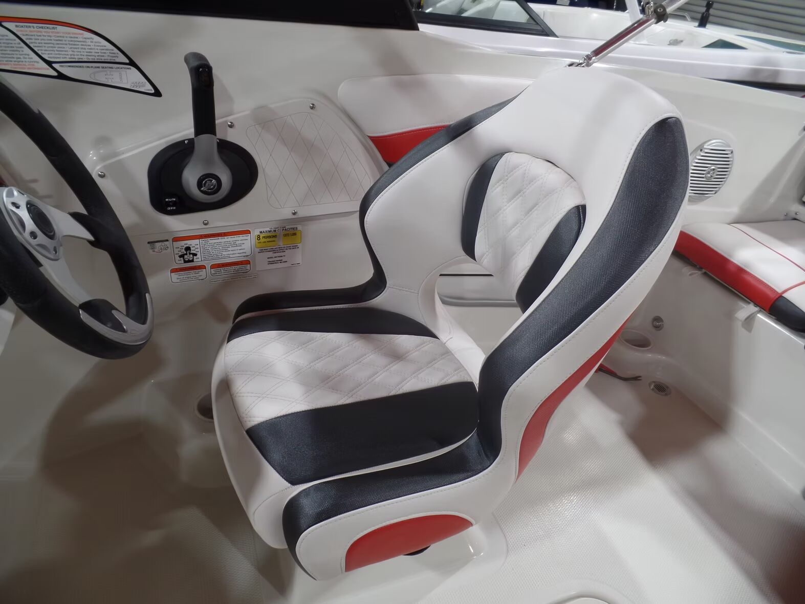 A boat with a black and white seat and steering wheel