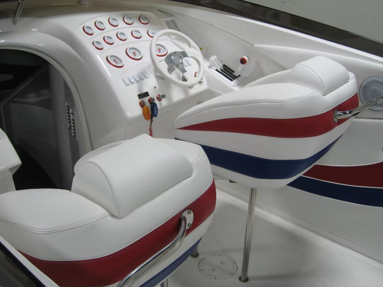 A boat with red white and blue seats and a steering wheel