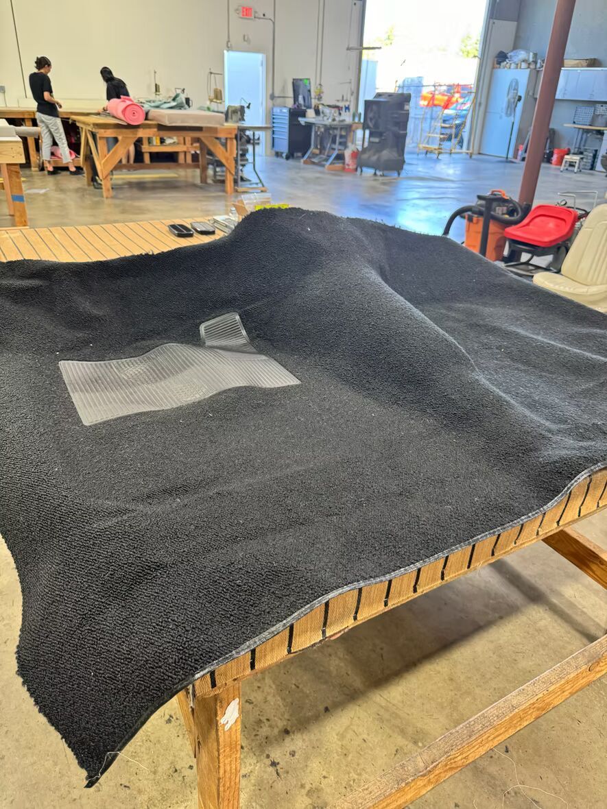 A large piece of black carpet is sitting on top of a wooden table.