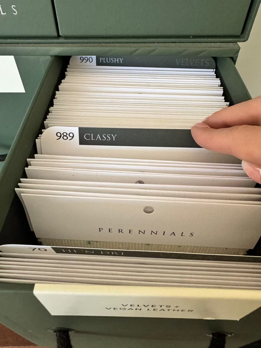 A person is pulling a card out of a filing cabinet labeled classy