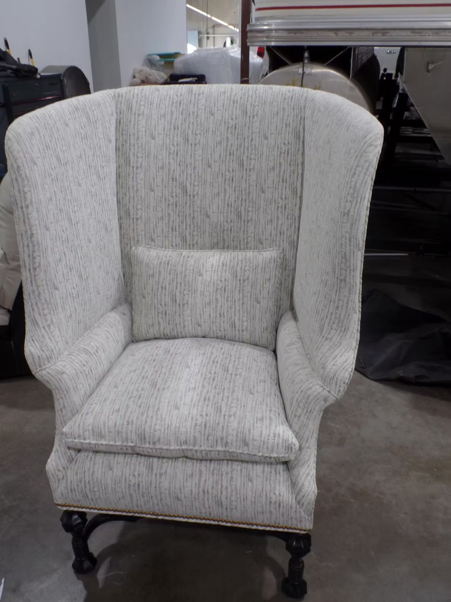 A white chair is sitting on a concrete floor