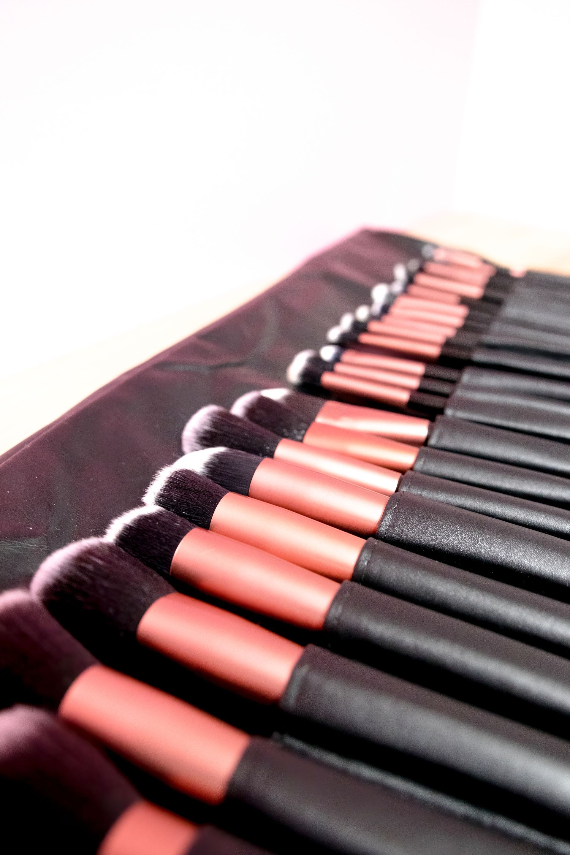 Makeup brush set in a black roll-up case. The brushes have black and rose gold handles. — Admire Skincare and Beauty in Taree, NSW