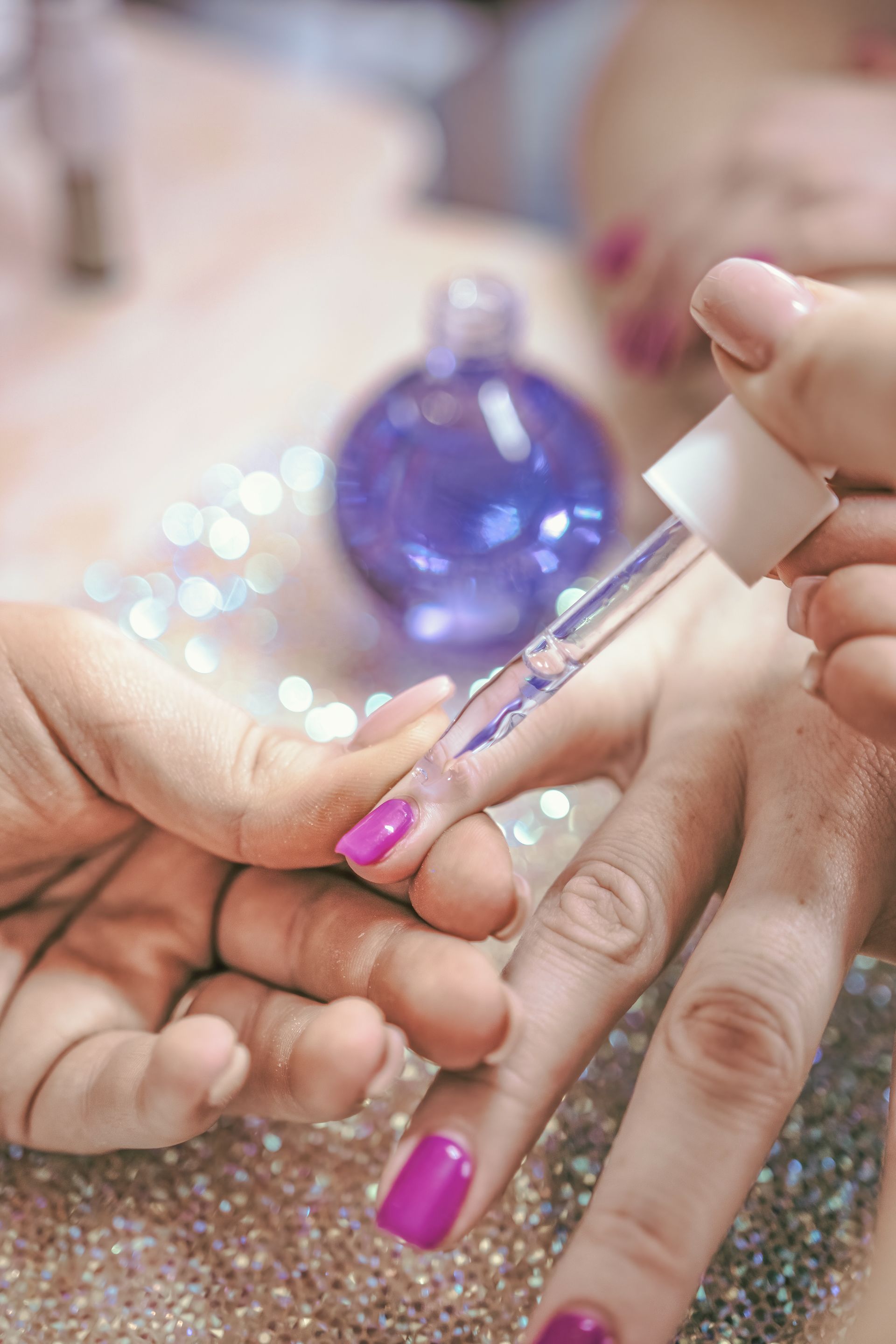 Hands With Light Pink and Glitter Nail Polish on a White Cloth — Admire Skincare and Beauty in Taree, NSW