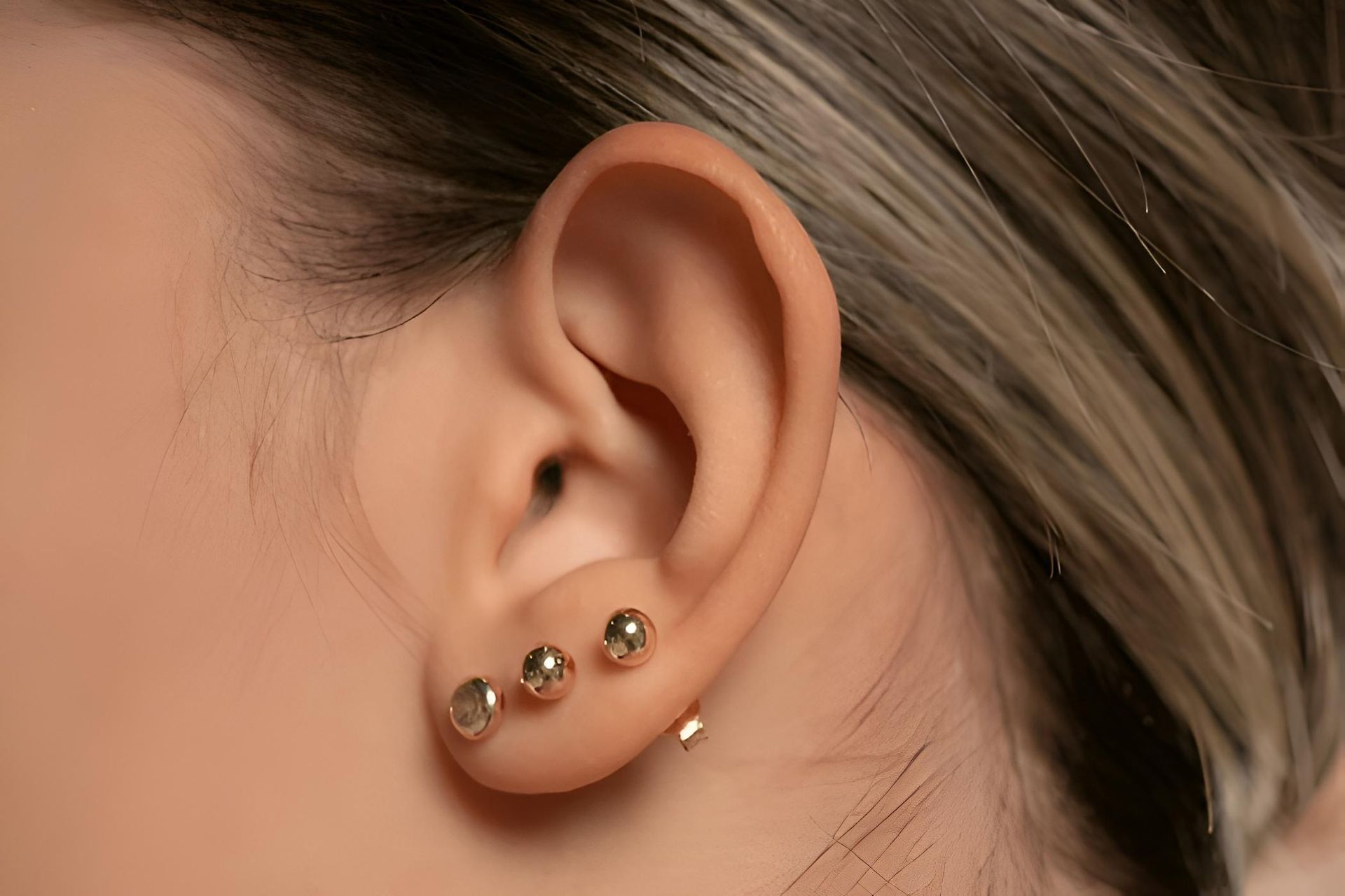 Ear With Three Gold Earrings — Admire Skincare and Beauty in Taree, NSW