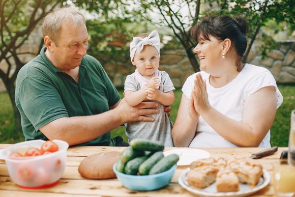 A man and a woman are sitting at a table with a baby.