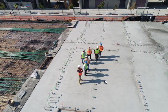 Construction workers cross a concrete foundation from an aerial view. Pic Scott Blake via Unsplash.