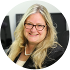 A woman in a tie dye shirt is smiling for the camera.