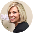 A man wearing glasses and a suit and tie is smiling for the camera.