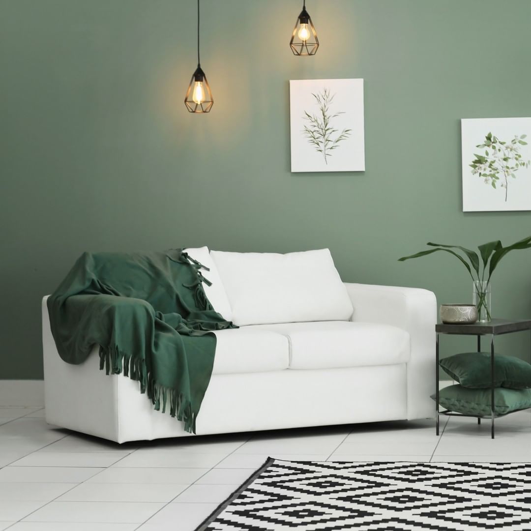A living room with green walls and a white couch — Taree Paint Centre in Taree, NSW