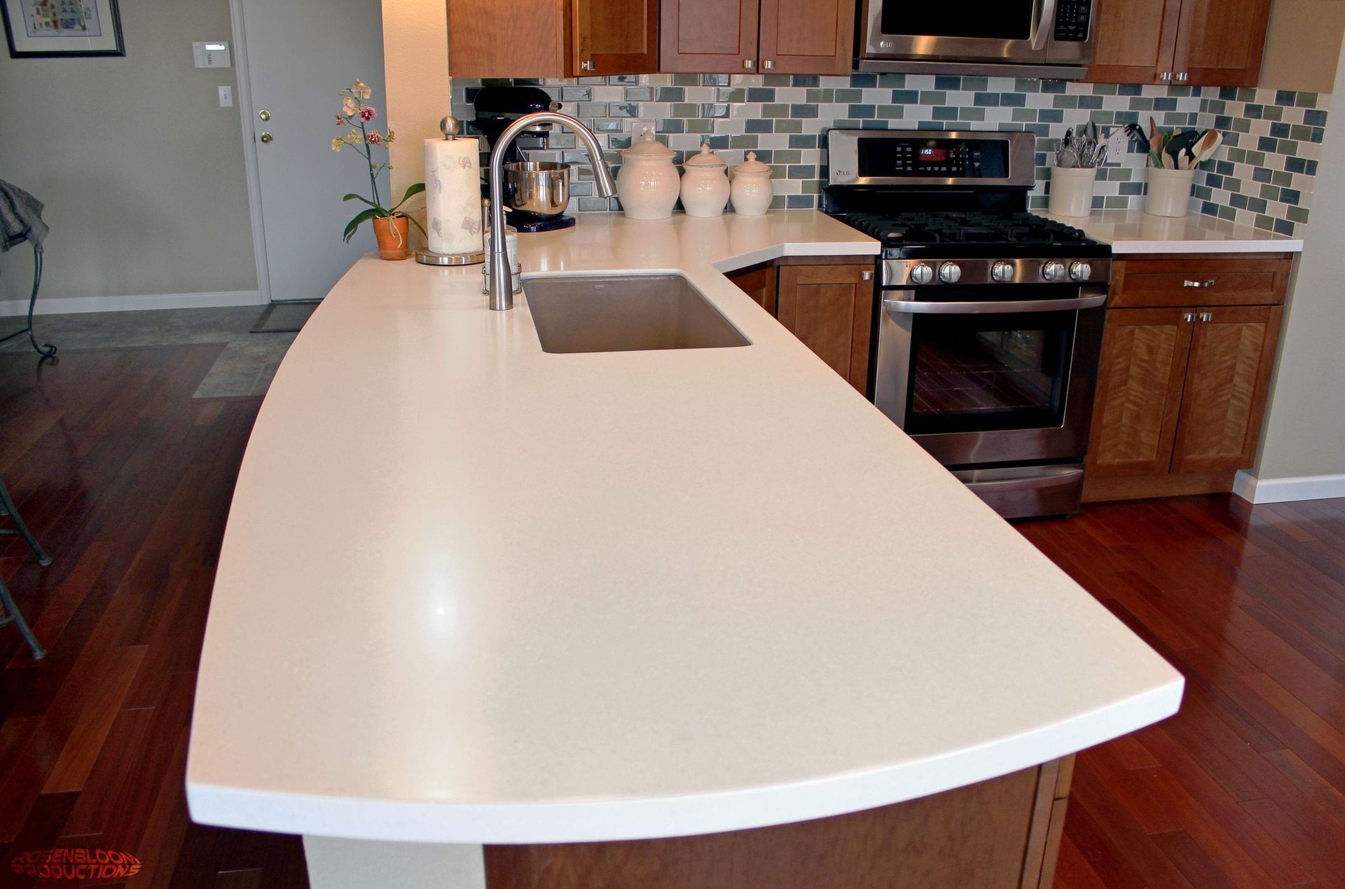 A kitchen with a white counter top and stainless steel appliances