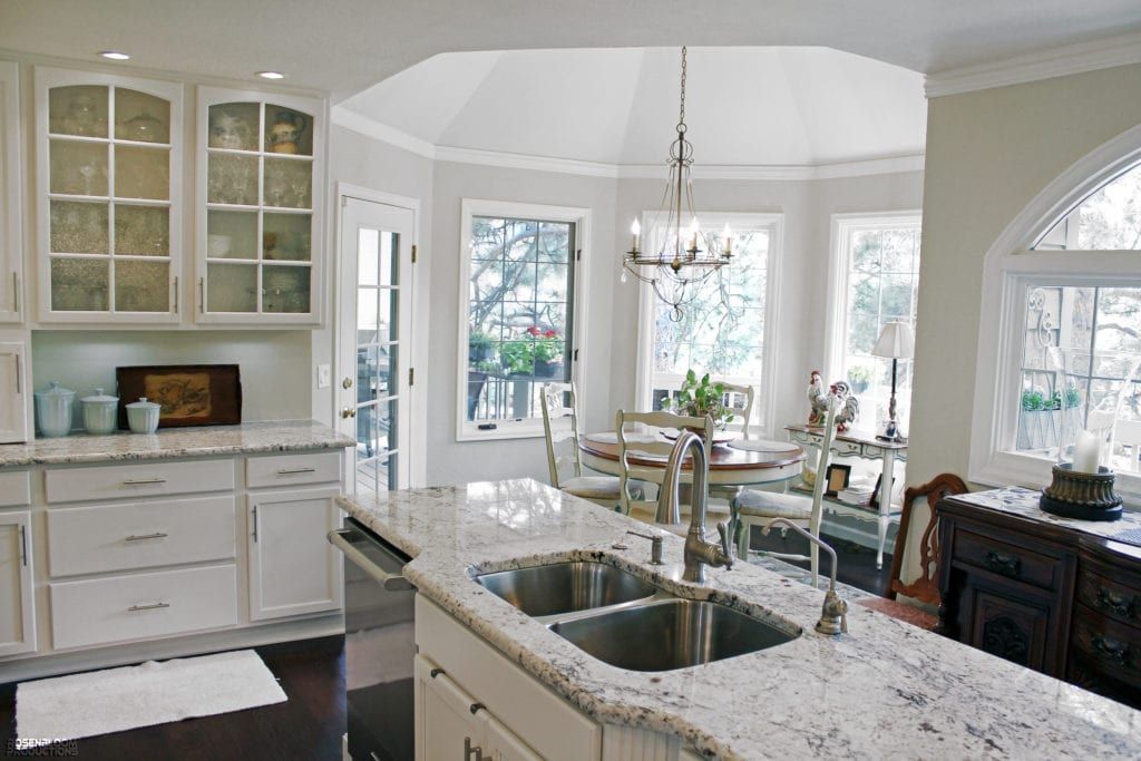 A kitchen with white cabinets and granite counter tops