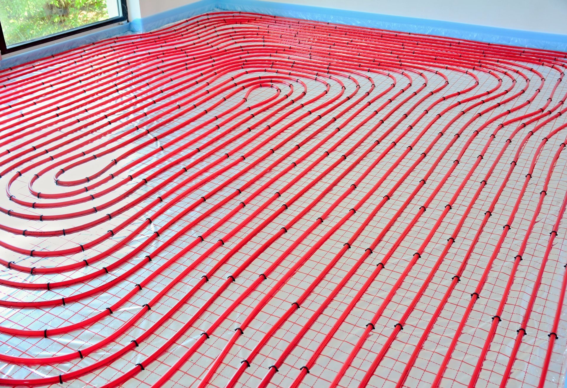 A room with a lot of red pipes on the floor.